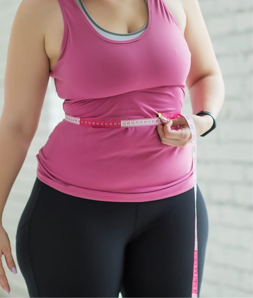 Woman measuring her waist