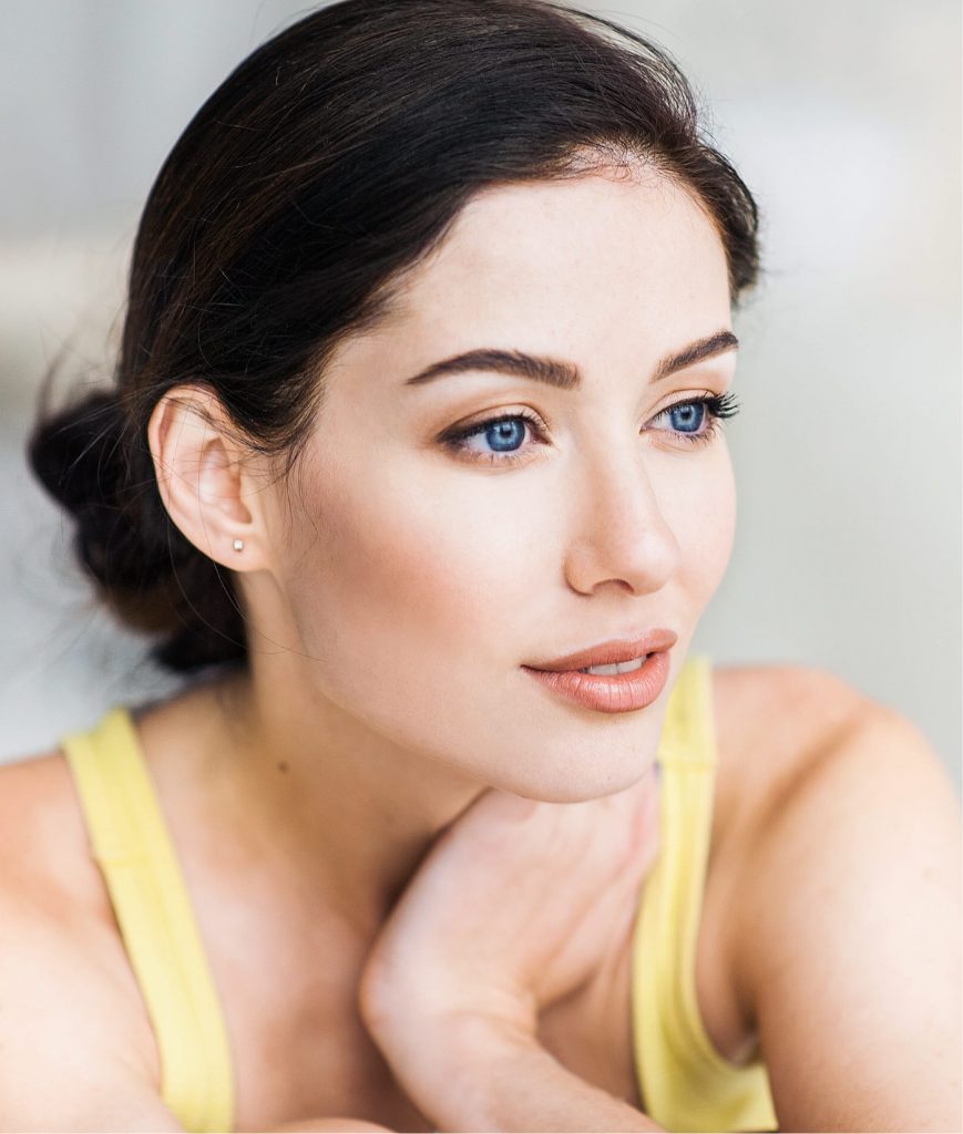 Woman with blue eyes wearing a yellow tank top