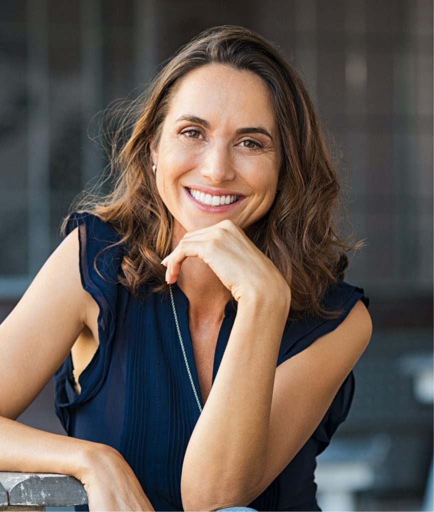 Brunette woman sitting outside at a table