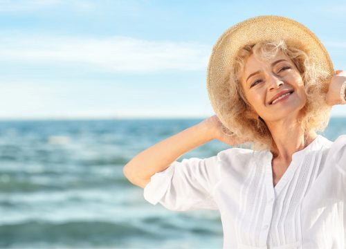 Older woman with varicose and spider veins at the beach
